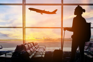 Person in an airport watching a plane takeoff